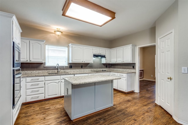 kitchen with dark wood-style floors, appliances with stainless steel finishes, white cabinets, and a sink