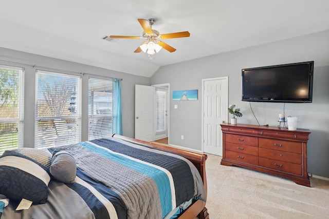 carpeted bedroom featuring vaulted ceiling, multiple windows, a ceiling fan, and visible vents