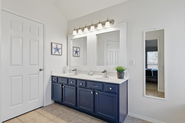 ensuite bathroom with a sink, connected bathroom, double vanity, and tile patterned flooring