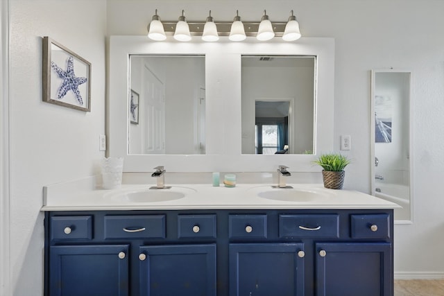 full bath with a sink, double vanity, and tile patterned flooring