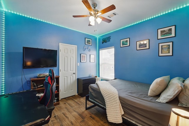 bedroom with ceiling fan, visible vents, and wood finished floors