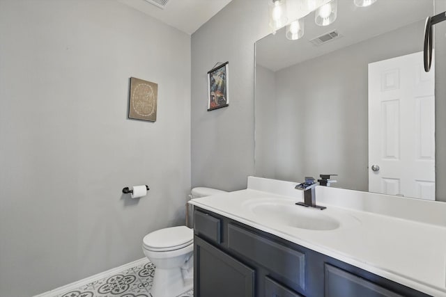 half bath with vanity, baseboards, visible vents, tile patterned flooring, and toilet