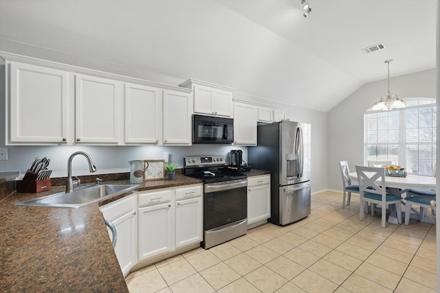 kitchen with dark countertops, visible vents, lofted ceiling, stainless steel appliances, and a sink