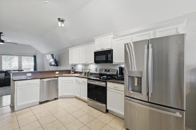 kitchen featuring dark countertops, stainless steel appliances, a peninsula, light tile patterned floors, and lofted ceiling