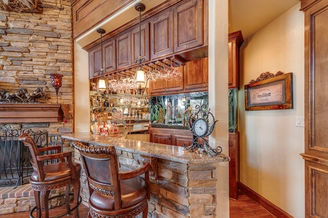 bar with baseboards, indoor wet bar, and wood finished floors