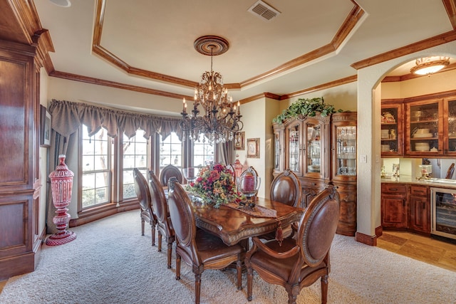 dining area featuring visible vents, a raised ceiling, indoor bar, light colored carpet, and wine cooler