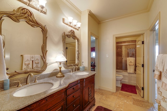 bathroom featuring double vanity, crown molding, toilet, and a sink