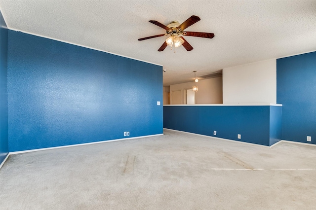 carpeted empty room with baseboards, a ceiling fan, a textured ceiling, and a textured wall