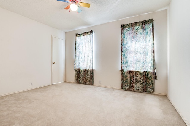 unfurnished room featuring a textured ceiling, carpet floors, and a ceiling fan