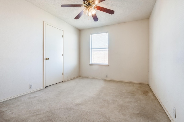 spare room with carpet floors, a ceiling fan, and a textured ceiling