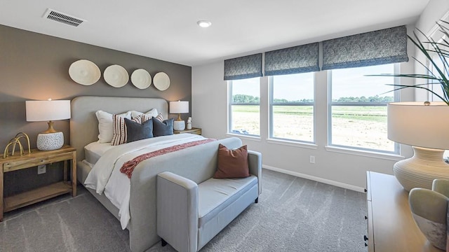 carpeted bedroom with visible vents and baseboards