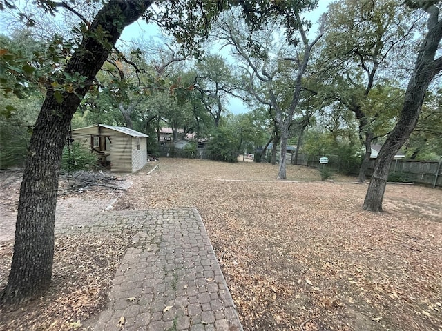 view of yard featuring fence and an outbuilding