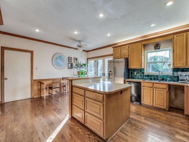 kitchen with dishwasher, stainless steel fridge with ice dispenser, a kitchen island, ornamental molding, and wood finished floors