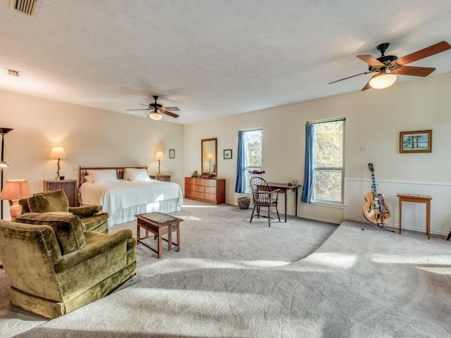 carpeted bedroom with ceiling fan and visible vents