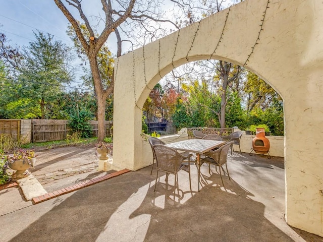 view of patio with outdoor dining space and fence