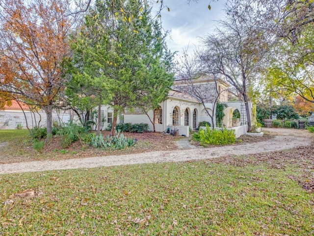 mediterranean / spanish-style house featuring a front lawn and stucco siding