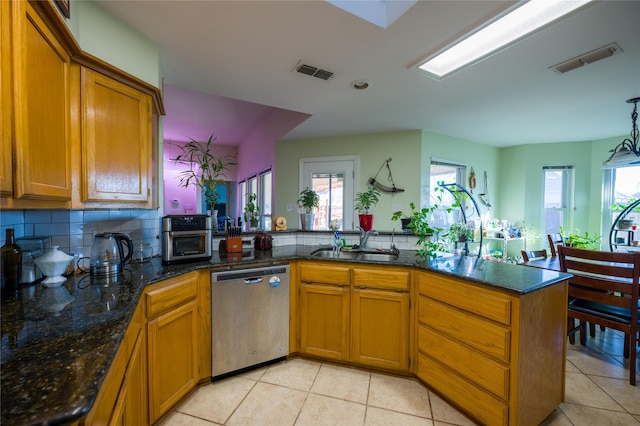 kitchen featuring a sink, visible vents, brown cabinets, and stainless steel dishwasher