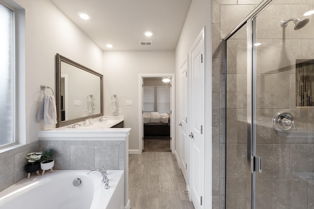 full bath featuring ensuite bathroom, a garden tub, wood finished floors, visible vents, and a stall shower