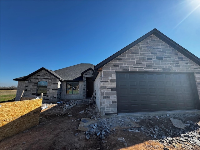 view of front of house with an attached garage and roof with shingles