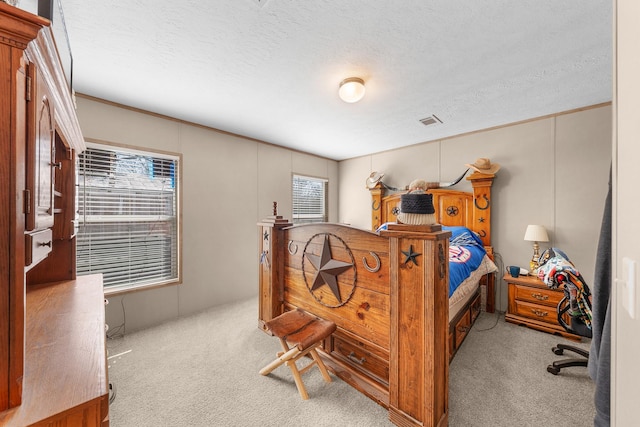 bedroom with a textured ceiling, carpet flooring, and visible vents