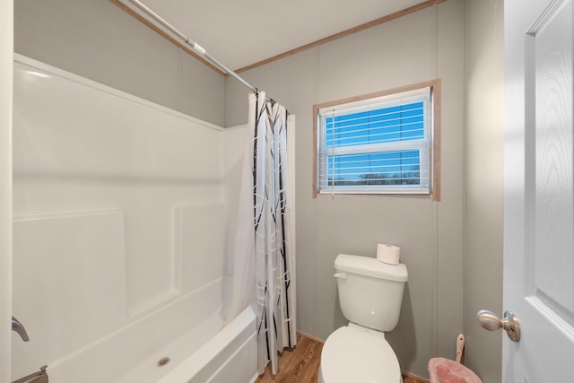 full bath featuring shower / tub combo, wood finished floors, and toilet