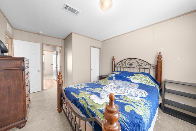 bedroom with visible vents, crown molding, and carpet flooring