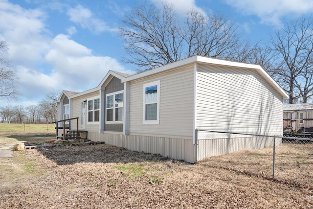 view of side of home featuring entry steps and fence