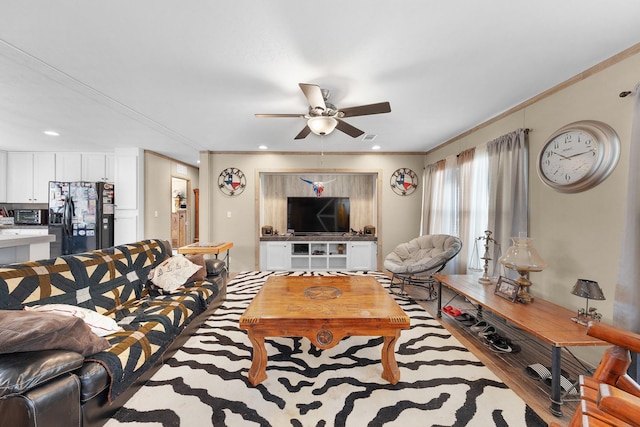 living area featuring a ceiling fan, crown molding, and wood finished floors