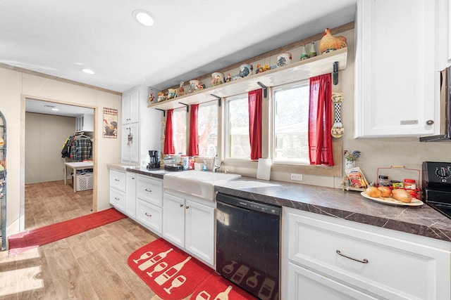 kitchen with dishwasher, a sink, light wood-style flooring, and white cabinets