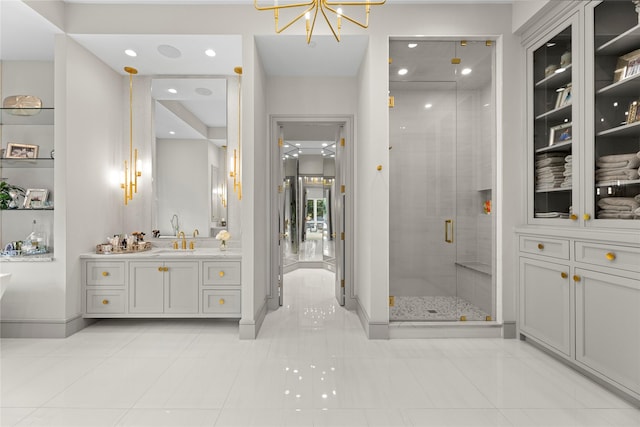 full bath featuring a stall shower, baseboards, tile patterned floors, an inviting chandelier, and vanity