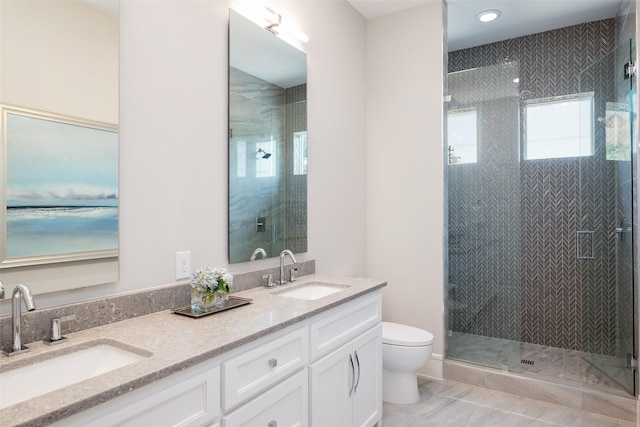 full bath featuring double vanity, a stall shower, a sink, and toilet