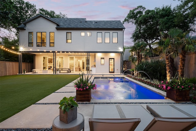 back of house at dusk featuring a patio area, a fenced backyard, a fenced in pool, and a yard