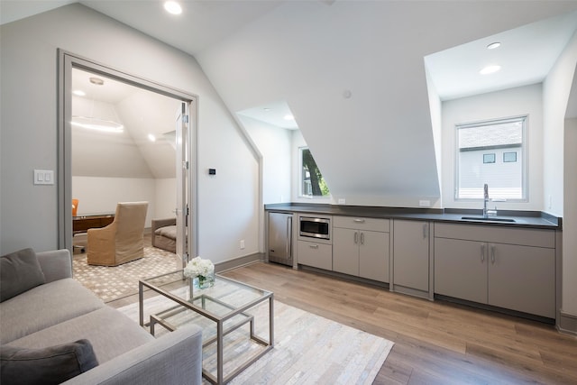 living room with recessed lighting, a healthy amount of sunlight, vaulted ceiling, and light wood finished floors