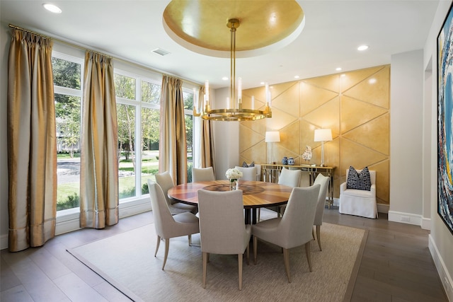 dining space featuring a notable chandelier, recessed lighting, a raised ceiling, visible vents, and wood finished floors