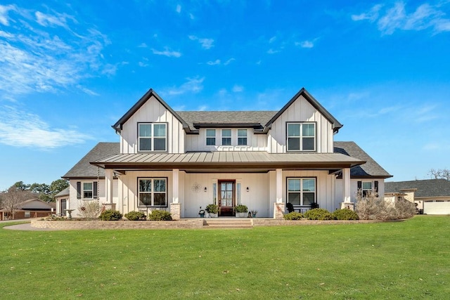 modern inspired farmhouse featuring a standing seam roof, metal roof, a front lawn, and board and batten siding