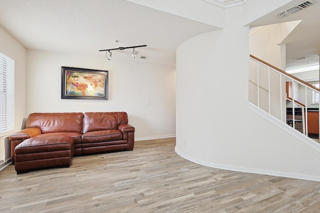 living area featuring visible vents, stairway, baseboards, and wood finished floors