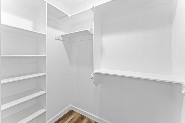 walk in closet with wood finished floors