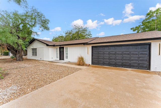 single story home with a garage, brick siding, and driveway