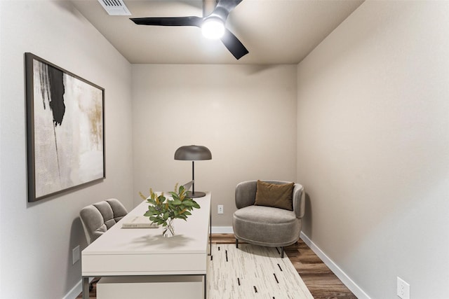 office space featuring visible vents, ceiling fan, baseboards, and wood finished floors