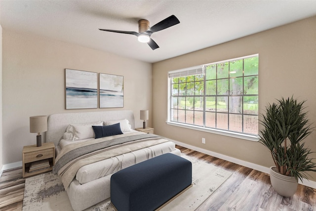 bedroom with ceiling fan, baseboards, and wood finished floors