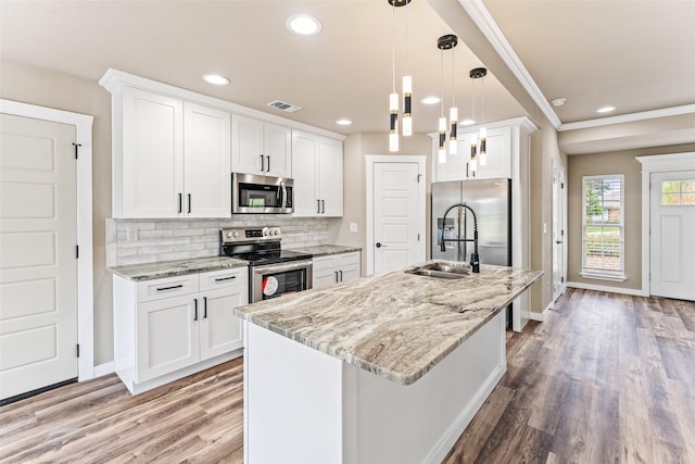 kitchen featuring visible vents, appliances with stainless steel finishes, white cabinets, and backsplash