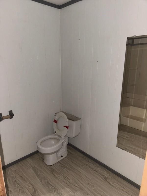 bathroom with toilet and wood finished floors