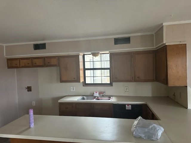 kitchen with light countertops, a sink, visible vents, and brown cabinets