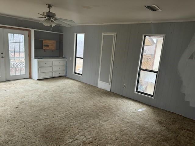 interior space featuring french doors, crown molding, visible vents, carpet flooring, and ceiling fan