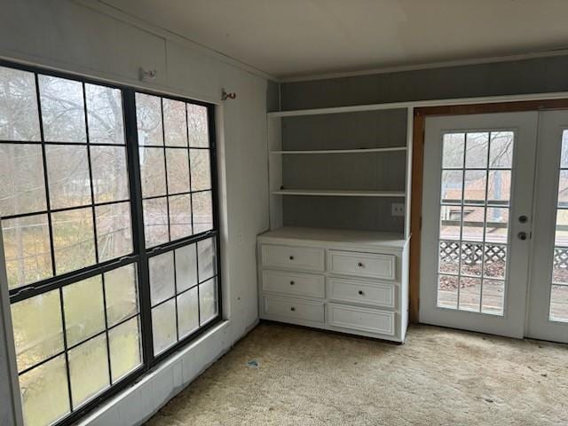 entryway featuring light carpet, a wealth of natural light, and french doors