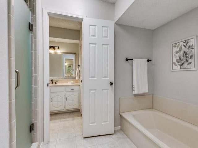 full bathroom with a stall shower, a garden tub, vanity, and tile patterned floors