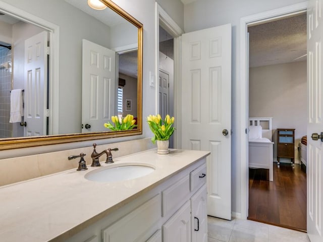 full bathroom featuring tile patterned flooring, vanity, and a textured ceiling