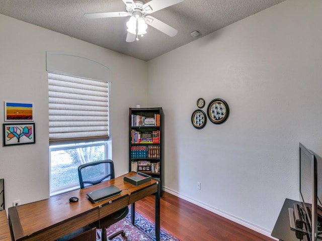 home office with a textured ceiling, ceiling fan, wood finished floors, and baseboards