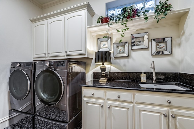 washroom with crown molding, washing machine and dryer, cabinet space, and a sink