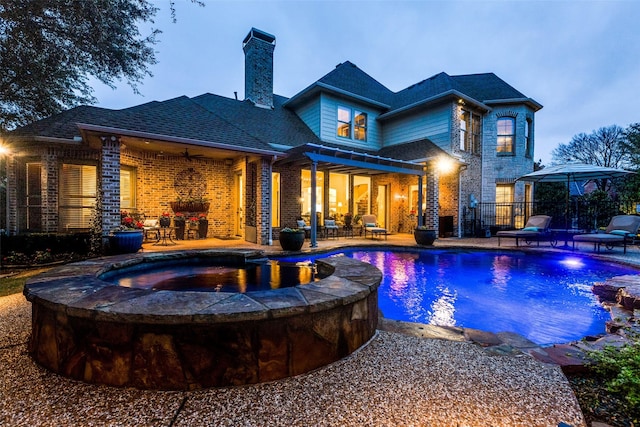 exterior space featuring a pool with connected hot tub, fence, a ceiling fan, and a patio